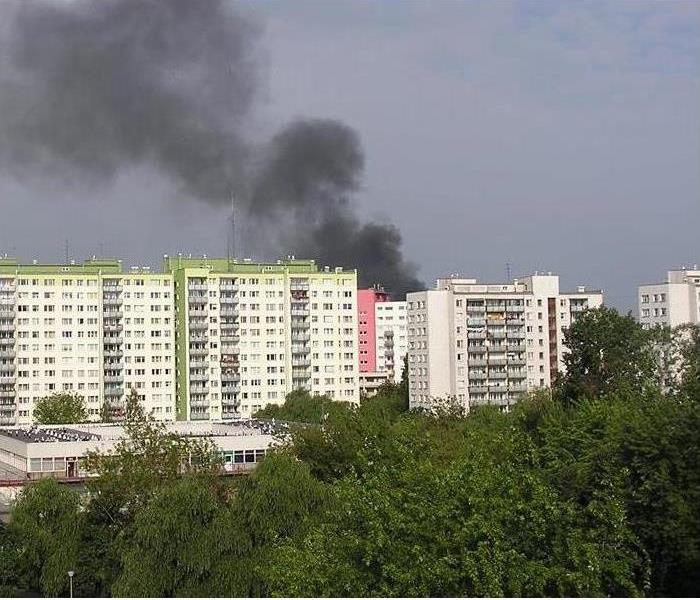 multiple high rise buildings with black smoke rising from top