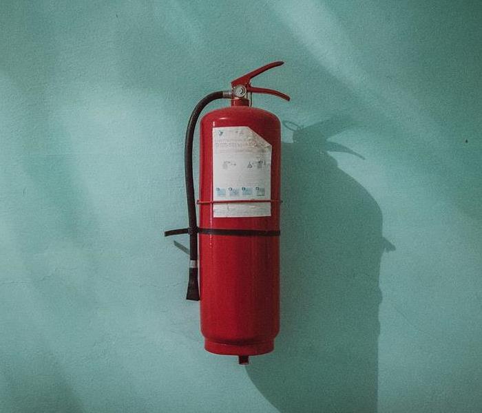 Fire extinguisher on teal wall